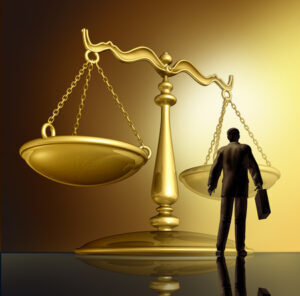 Scales of justice with silhouette of attorney under them.